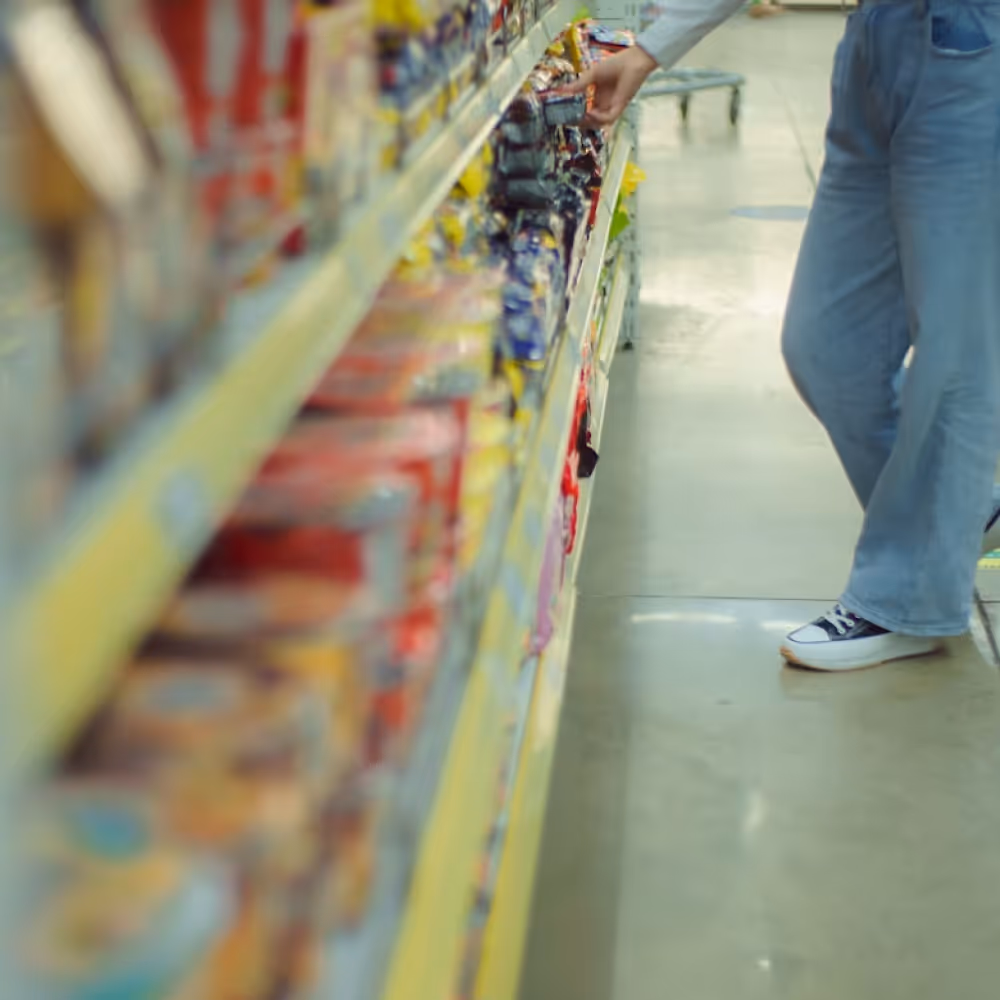 Customer evaluating snack packaging on a retail shelf, showcasing the importance of shelf appeal for D2C food and FMCG brands